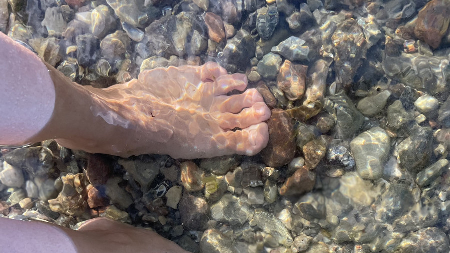 Füße im Meer und mit Sand